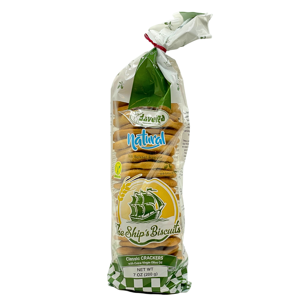 A 7 oz bag of Darleya Natural Ship’s Biscuits, classic crackers made with extra virgin olive oil. The transparent packaging shows stacked golden crackers and features a green sailing ship logo with vegan certification, emphasizing a natural, Mediterranean-style snack.