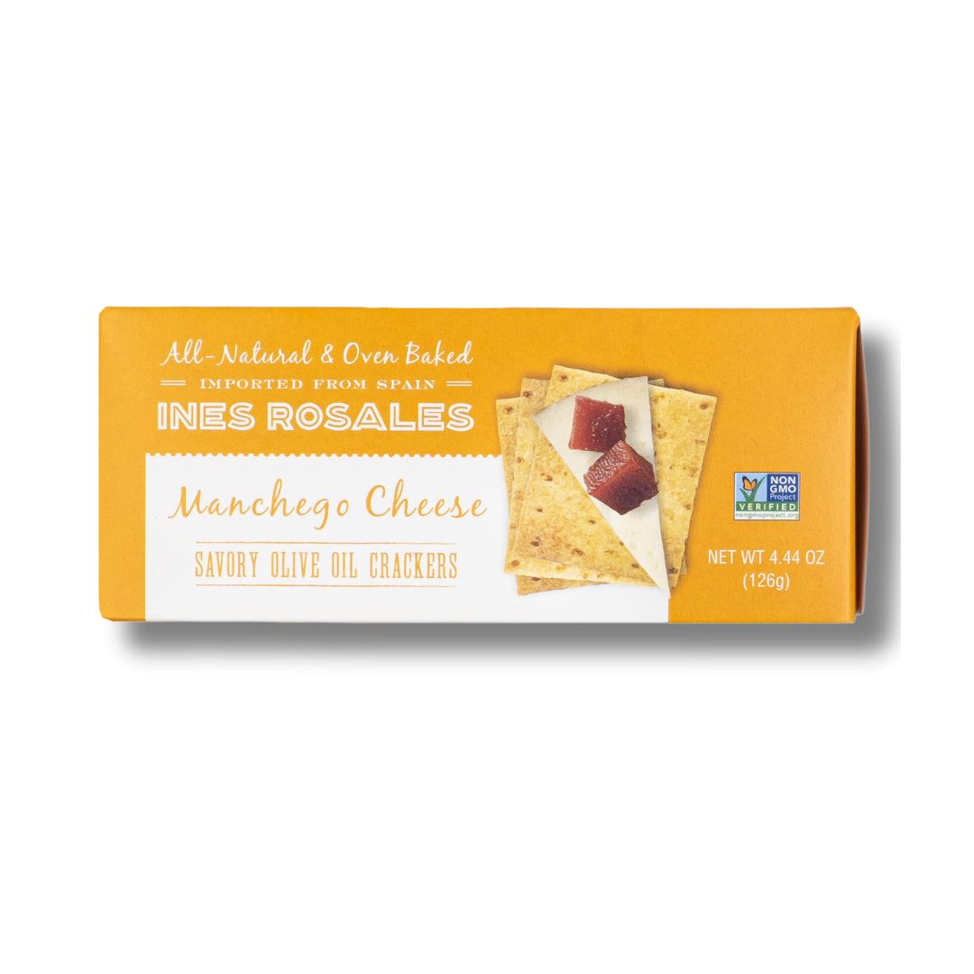 A rectangular orange and white box of INES ROSALES Manchego Cheese Savory Olive Oil Crackers, labeled as all-natural, oven-baked, and imported from Spain. The box displays crackers topped with a slice of Manchego cheese and cubes of quince paste. It is marked Non-GMO Project Verified and weighs 4.44 oz (126g).