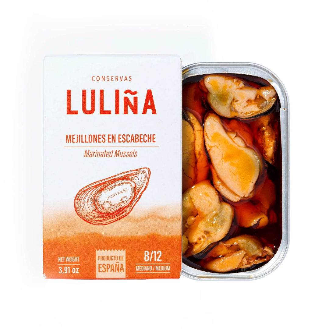 A tin can of Luliña brand Mejillones en Escabeche, showing the label and the mussels inside the open can.