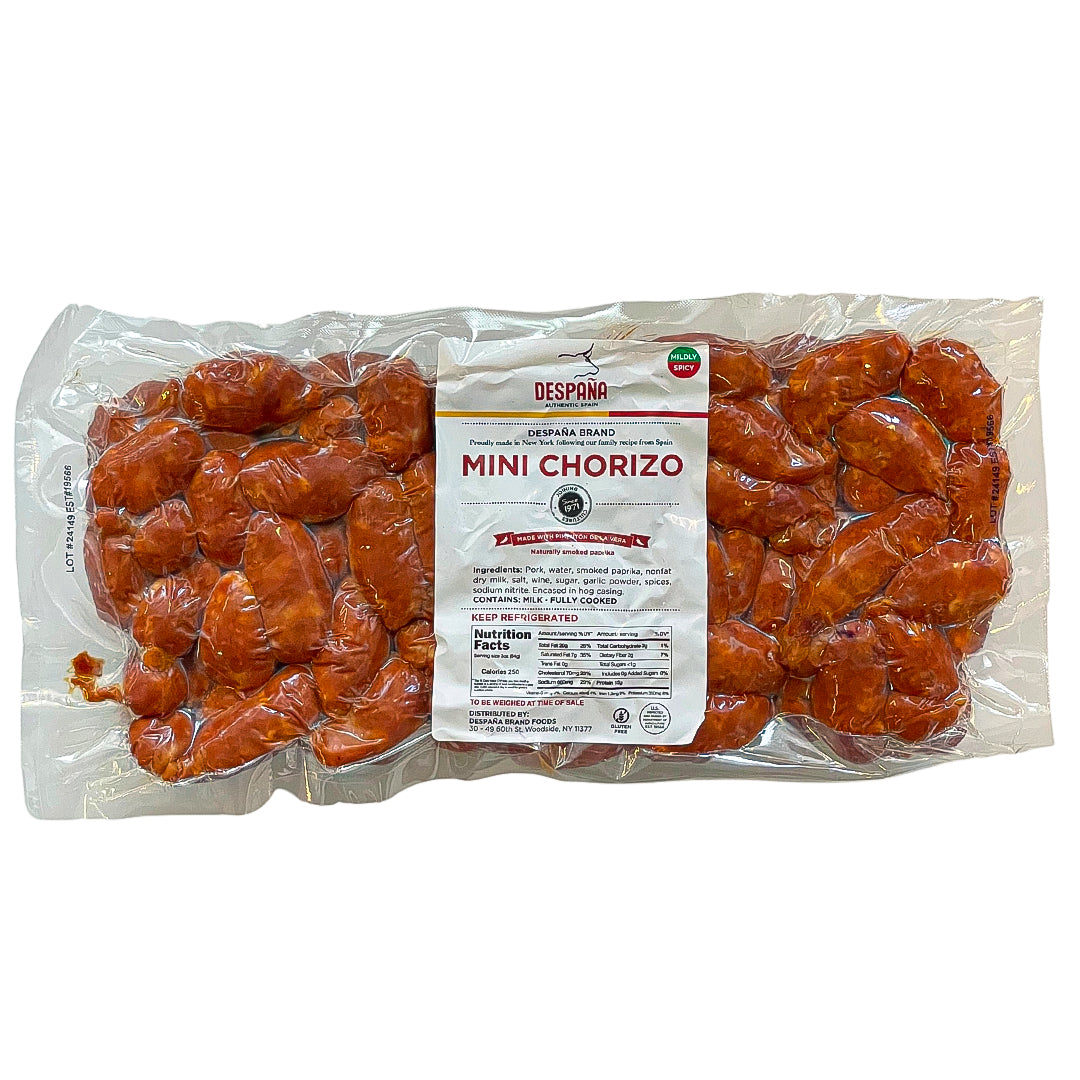 A large vacuum-sealed pack of Despaña Mini Chorizo with a white label and "Mildly Spicy" badge. Fully cooked and seasoned with Pimentón de la Vera, these gluten-free sausages offer bold, smoky Spanish flavor in a snackable size.