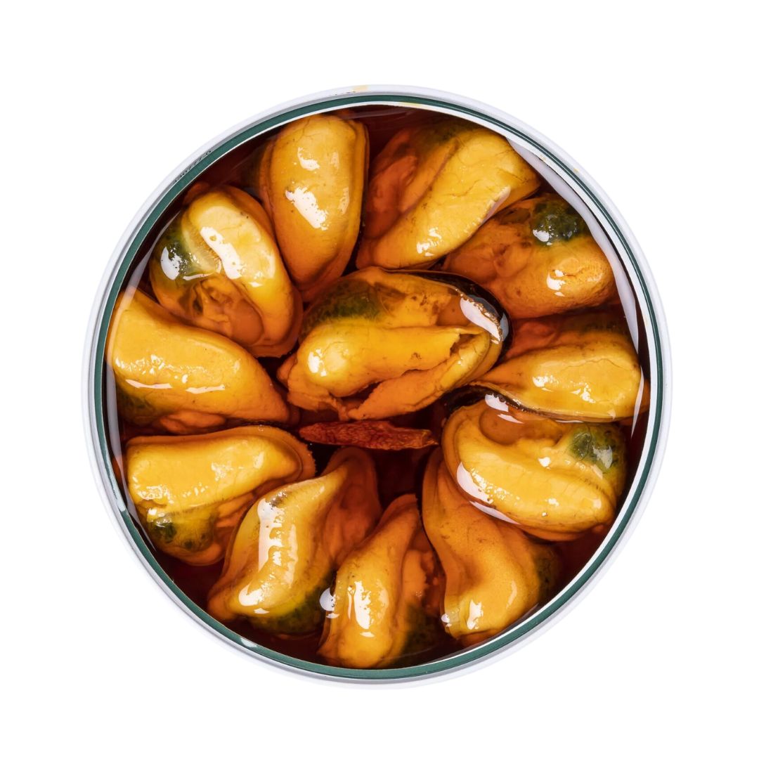 The opened tin reveals plump, golden-yellow mussels nestled in a rich, red-orange marinade. Their glossy surface glistens under the light, a sign of their freshness and the quality of the spicy escabeche. The arrangement is tidy and appetizing—each mussel bathed in a vibrant Galician sauce that hints at paprika and vinegar, ready to be enjoyed straight from the can or atop crusty bread.