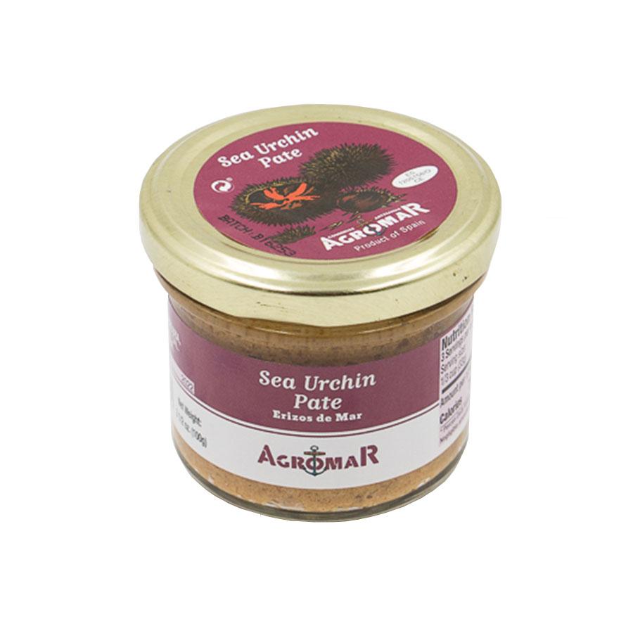 A glass jar of Agromar Sea Urchin Pâté (Erizos de Mar) with a golden metal lid. The jar features a maroon and white label that includes the brand name "Agromar" and product description in both English and Spanish. The lid also displays a sea urchin illustration along with the product name and brand. The pâté inside is light brown in color, visible through the transparent glass.