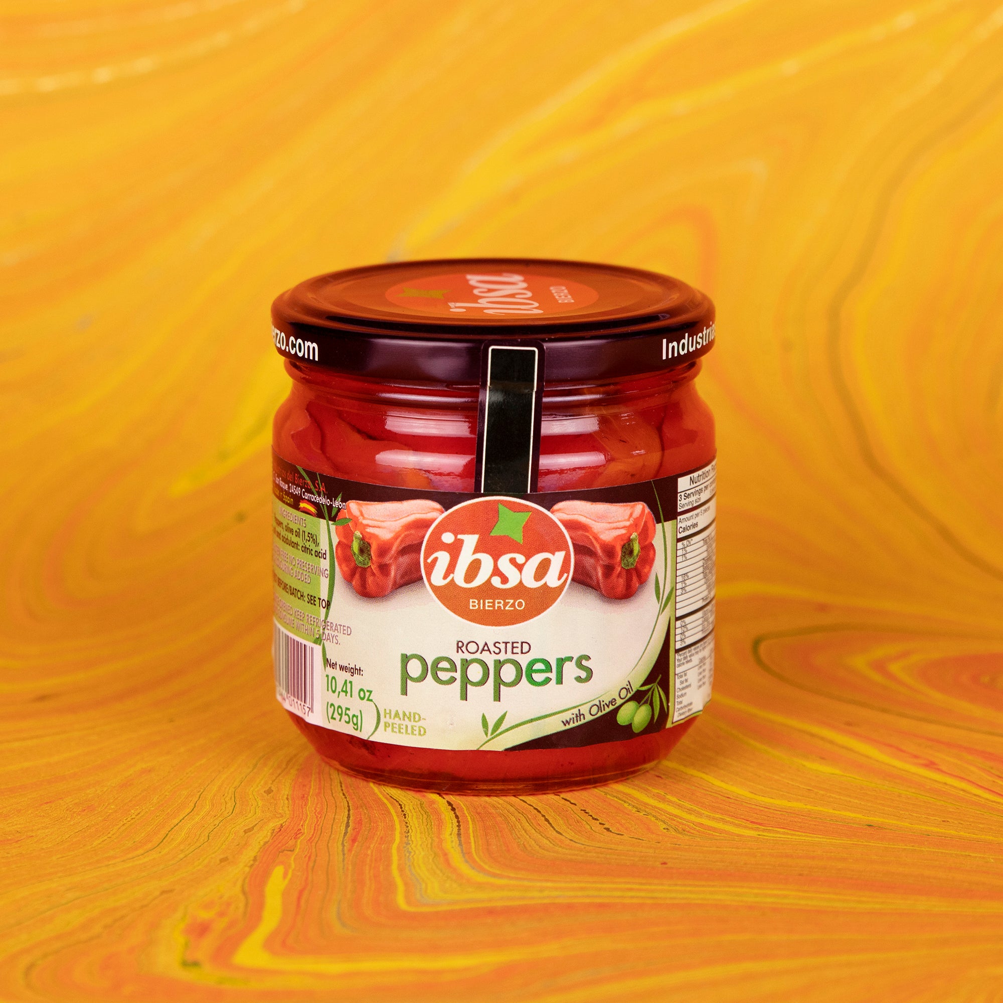 A product photo of a jar of roasted red peppers by the Ibsa brand.