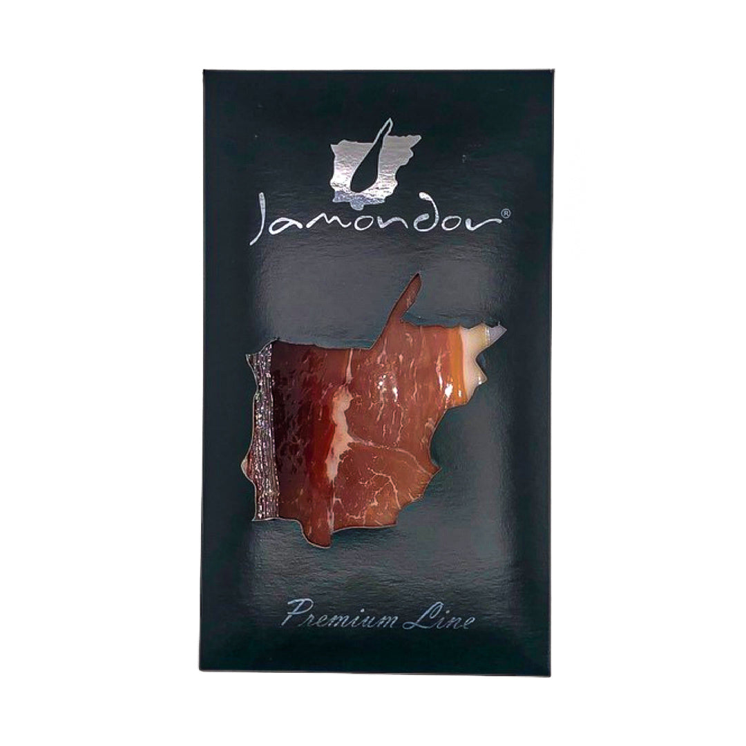 A sleek black package of Jamondor Premium Line ham, featuring a window in the shape of Spain that reveals rich marbled slices of cured Ibérico ham—an elegant tribute to traditional Spanish charcuterie.