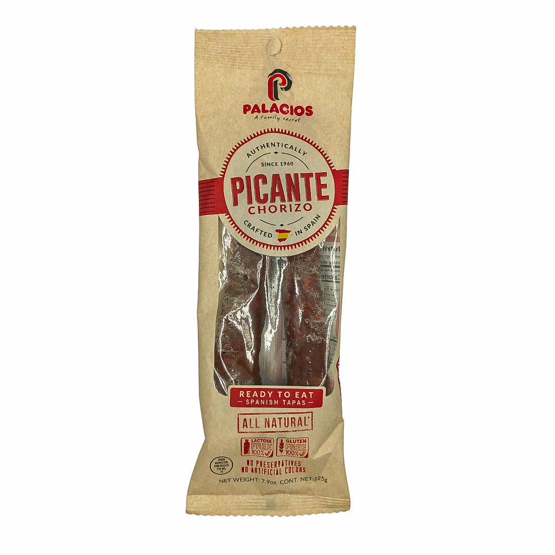 A package of Palacios Picante Chorizo features bold red and beige branding with clear labeling of its Spanish origin. The all-natural, ready-to-eat spicy chorizo is wrapped in eco-style kraft packaging, emphasizing its artisan quality and traditional flavor.