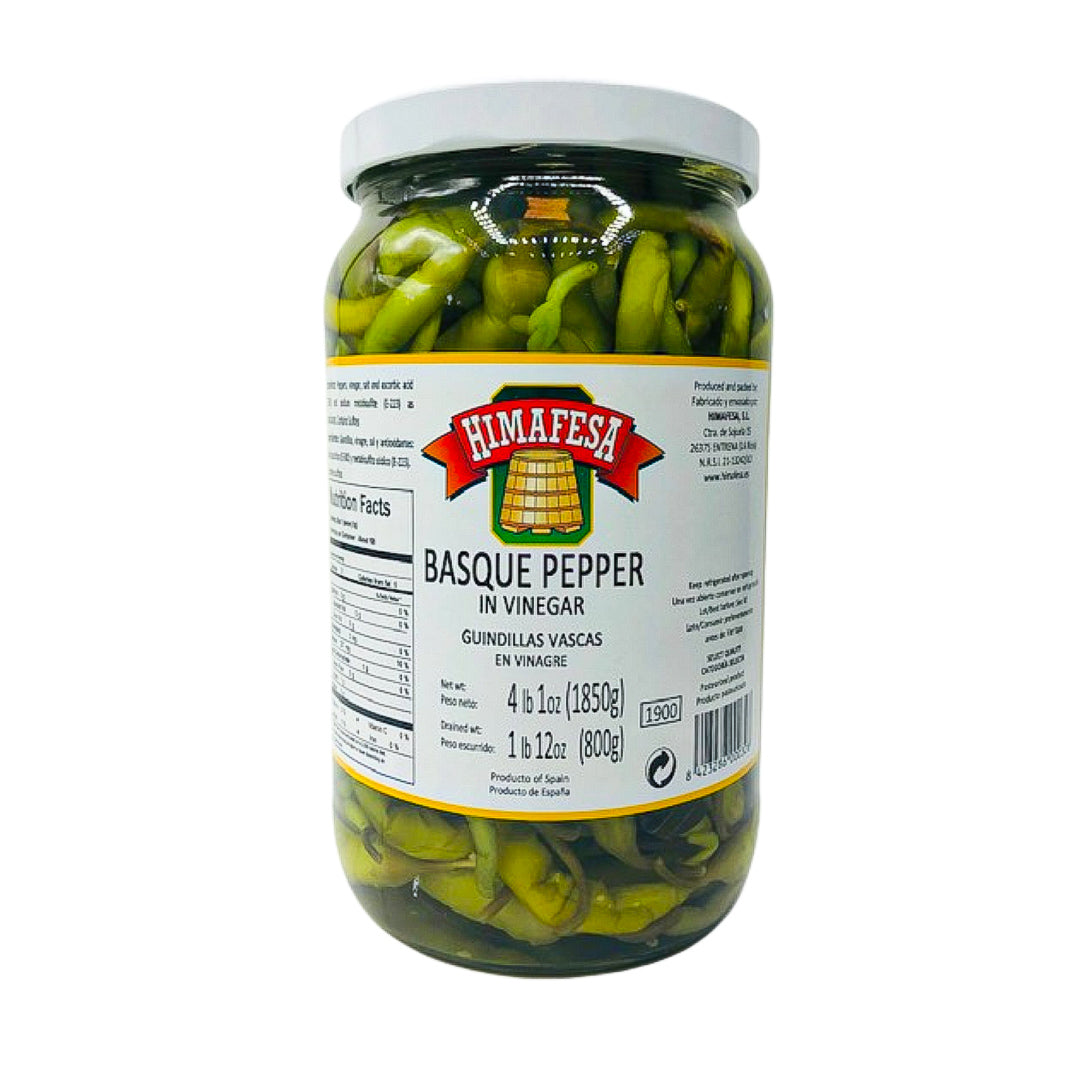 A clear jar of Himafesa guindilla peppers preserved in vinegar, showcasing premium whole green chili peppers. These Spanish-style pickled peppers add a tangy, mildly spicy kick to tapas, charcuterie boards, and Mediterranean recipes.