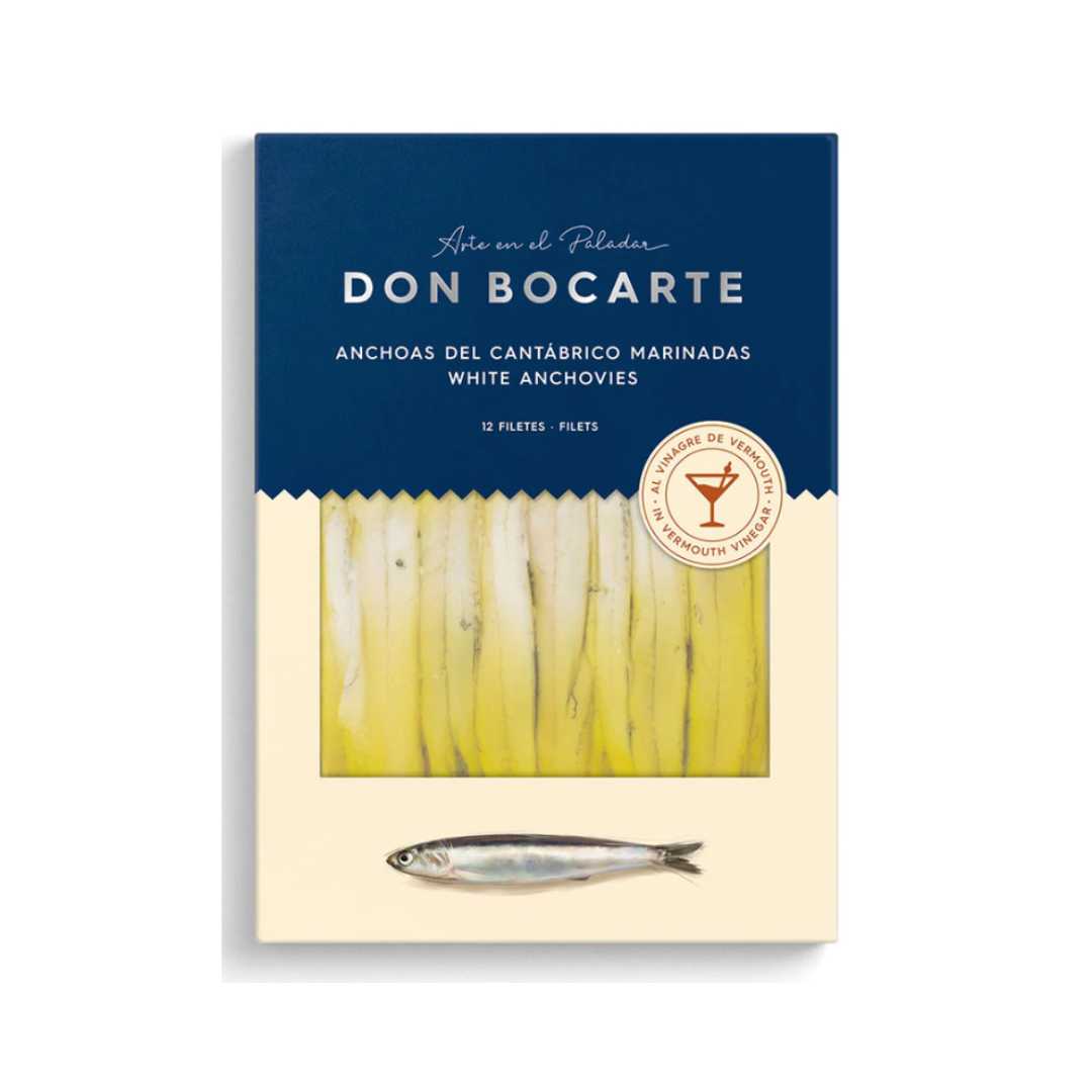 A premium pack of Don Bocarte Cantabrian white anchovies marinated in vermouth vinegar. The refined design features a window revealing 12 pristine fillets bathed in golden olive oil, with branding that evokes artisanal craftsmanship and northern Spanish tradition.