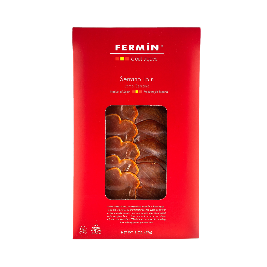 A sleek red package of Fermín Serrano Loin showcases delicately marbled slices through a central window. With minimalist design and premium Spanish origin, it captures the elegance of artisanal cured meats.