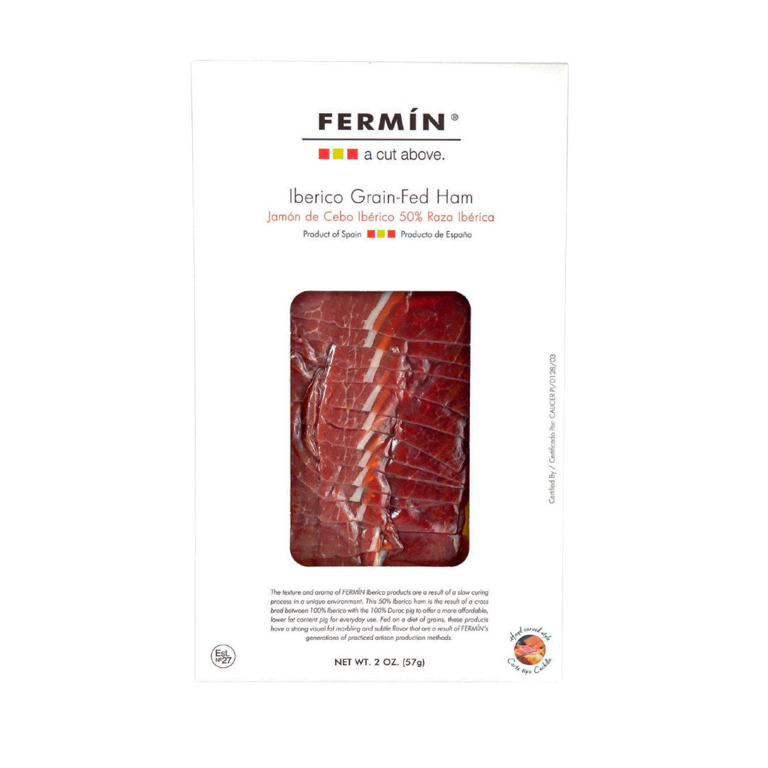 A 2 oz pack of Fermín Ibérico Grain-Fed Ham, displayed in sleek white packaging with a clear window. Made from 50% Ibérico breed, this Jamón de Cebo offers a rich, marbled cut ideal for everyday indulgence.