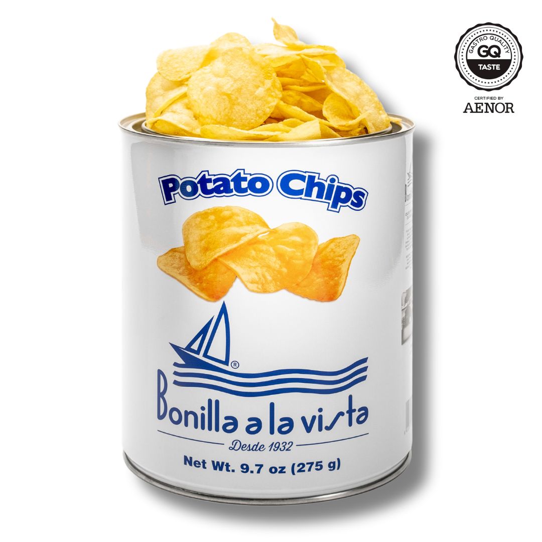 A 275g tin of Bonilla a la Vista potato chips. Featuring a graphic of four potato chips and a sailboat on the open seas. The top of the tin is open with the chips exposed. The GQ Taste award is highlighted. 